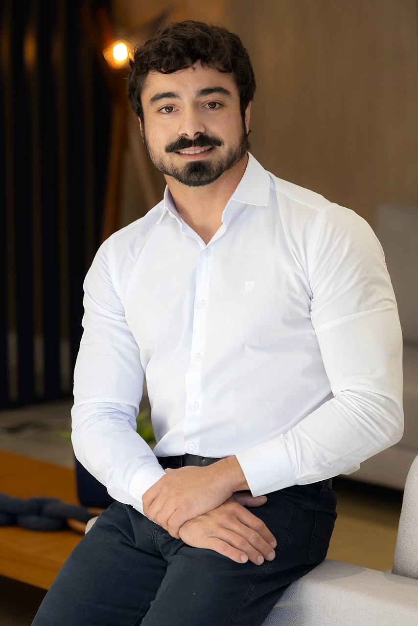 Dr. Gabriel Maluli de camisa branca, sorrindo